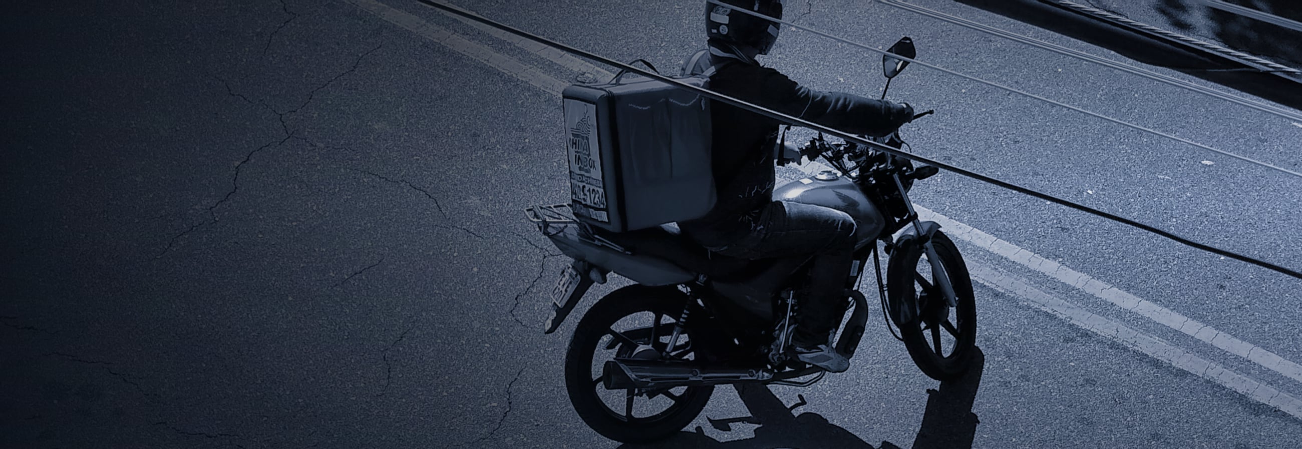Motoboy pilotando a motocicleta de trabalho em uma rua